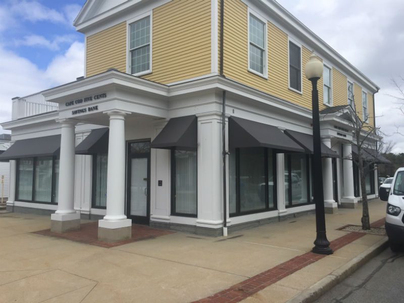 A building with two columns and a black pole.