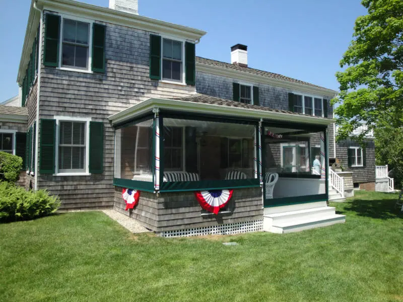 A house with a porch and a flag on the side.