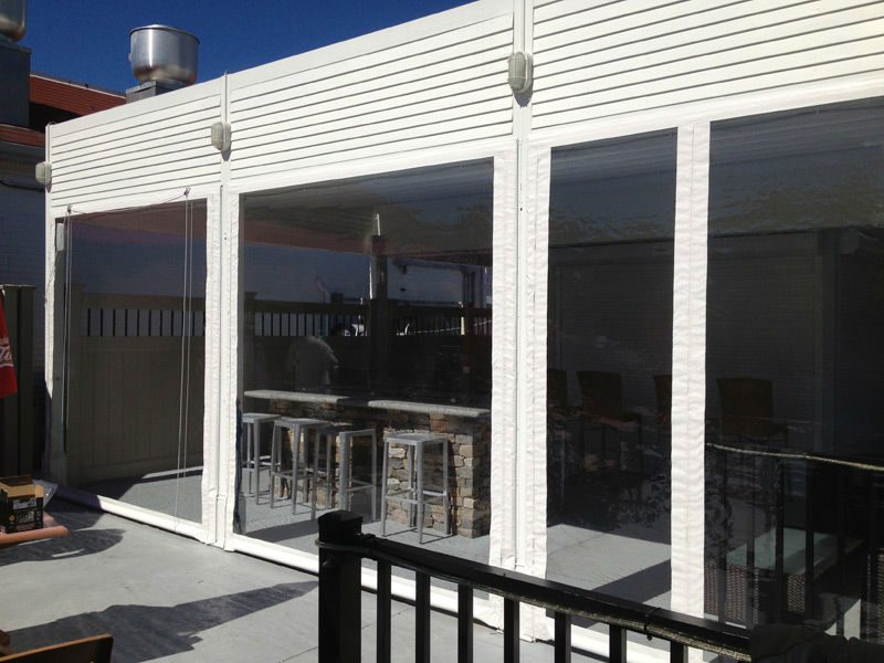 A large white building with glass windows and a metal railing.