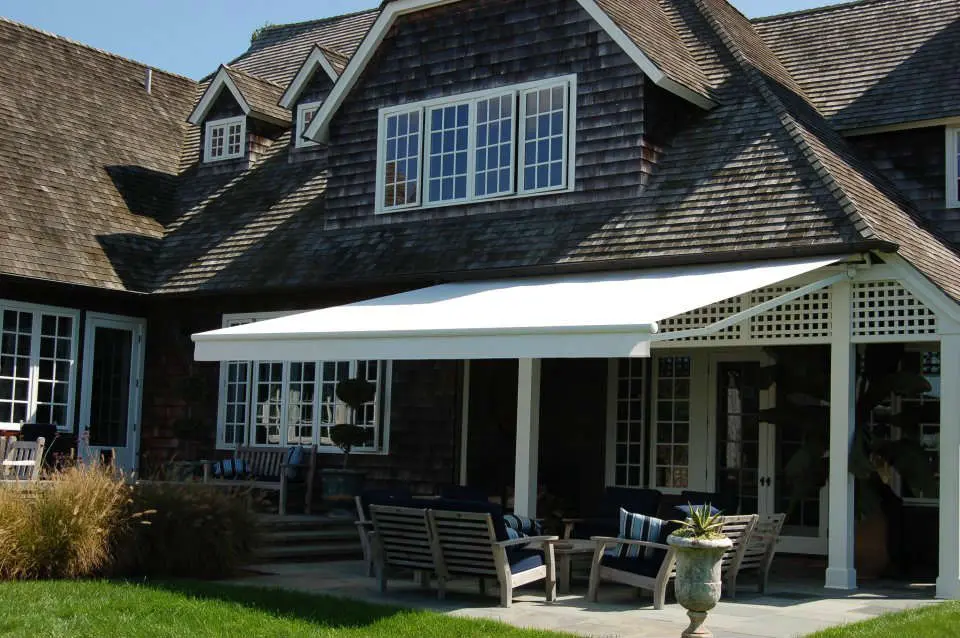 A house with a patio and awning on the front of it.