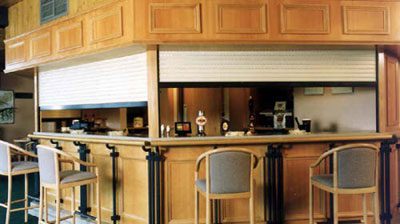 A kitchen with wooden cabinets and a bar.