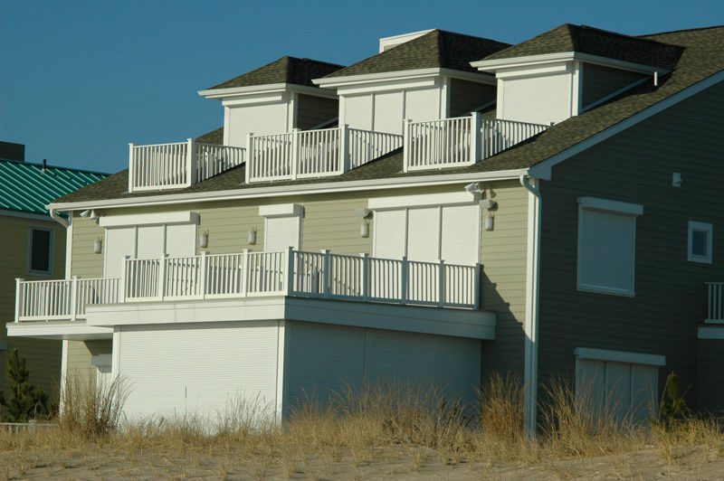 A large white house with balcony 's and railing.