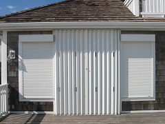 A white garage door with shutters on the side.