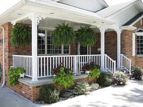 A porch with plants and flowers on it.