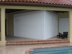 A pool enclosure with a sliding door and a brick wall.
