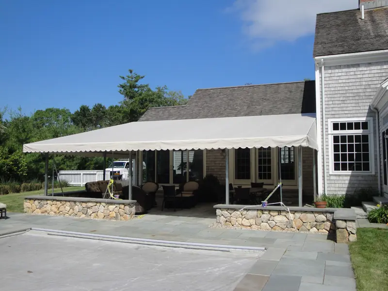 A house with a patio and awning on the side of it.