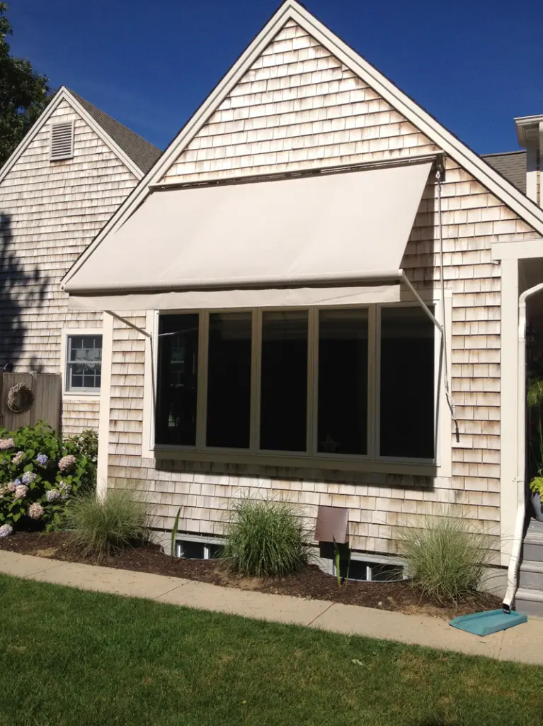 A house with a window and awning on the front of it.