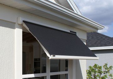 A black awning is attached to the side of a house.